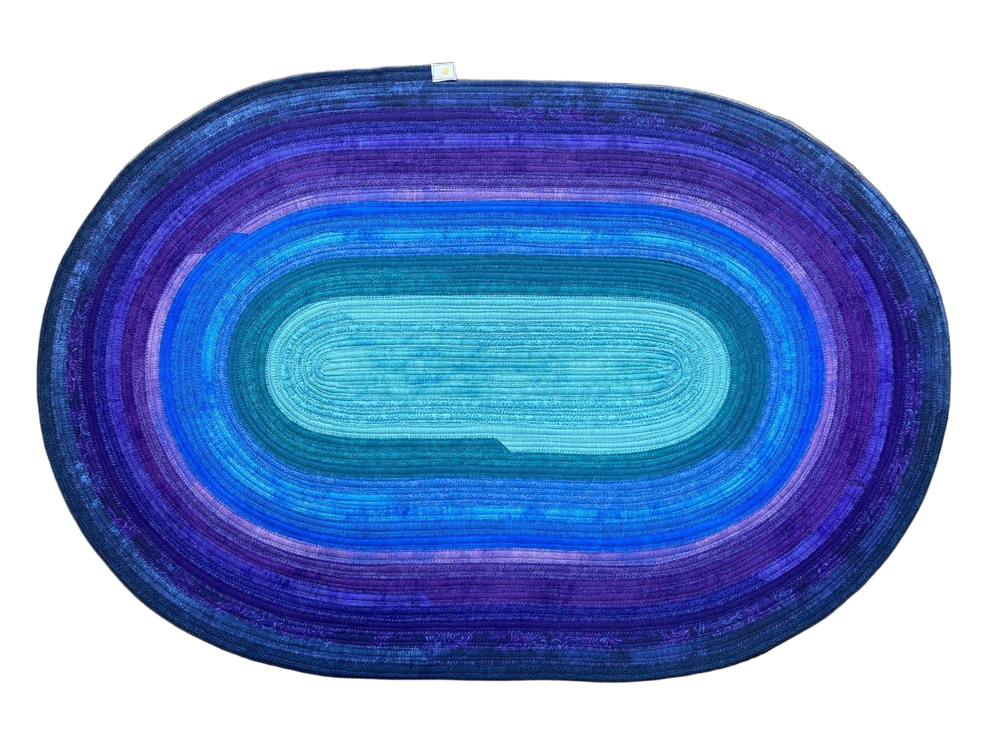 Oval-shaped rug with blue and purple gradient on a wooden floor