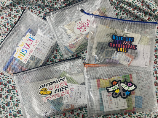 Clear mesh pouches with colorful text and graphics on a patterned surface