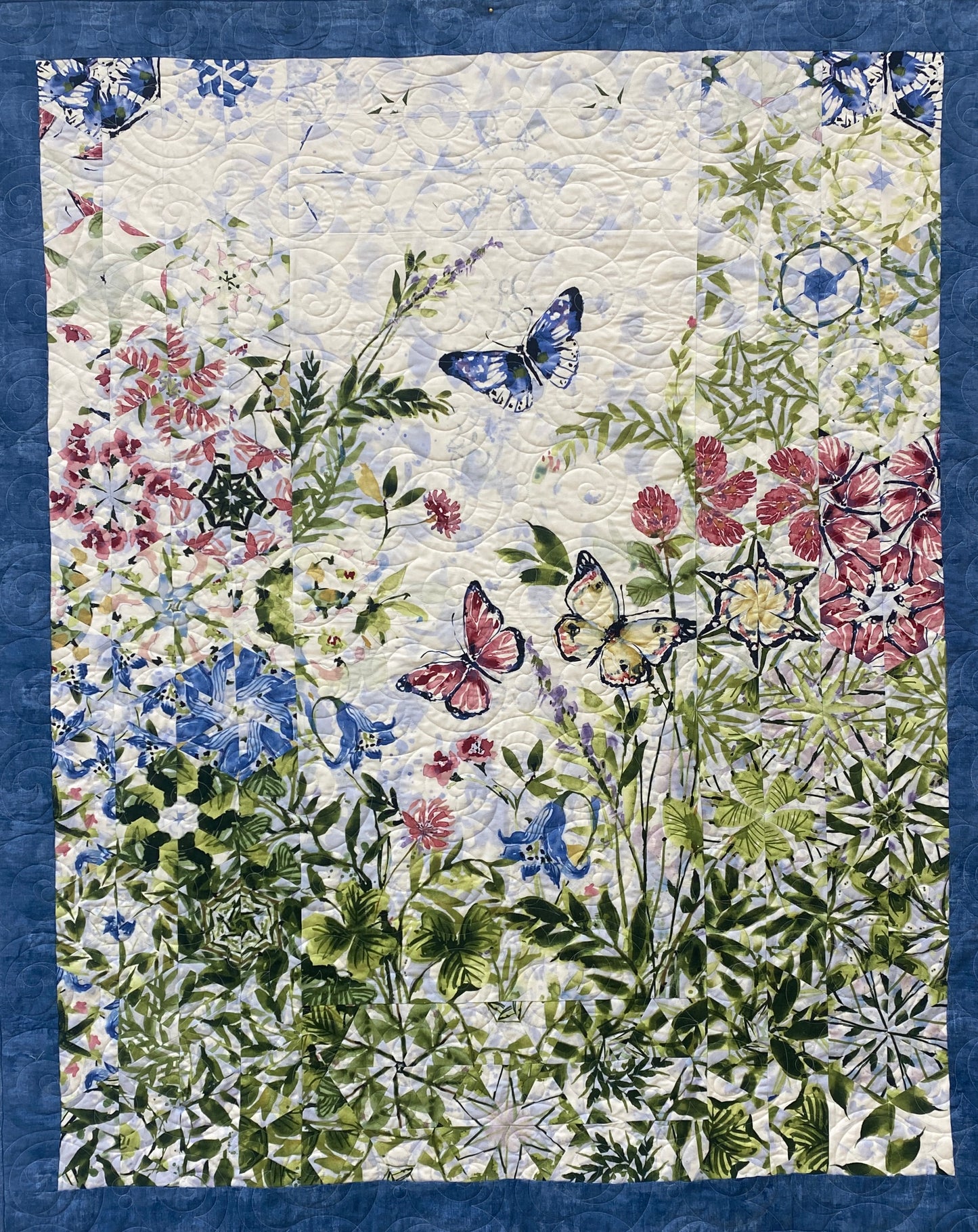 Quilt with floral and butterfly pattern on a blue background