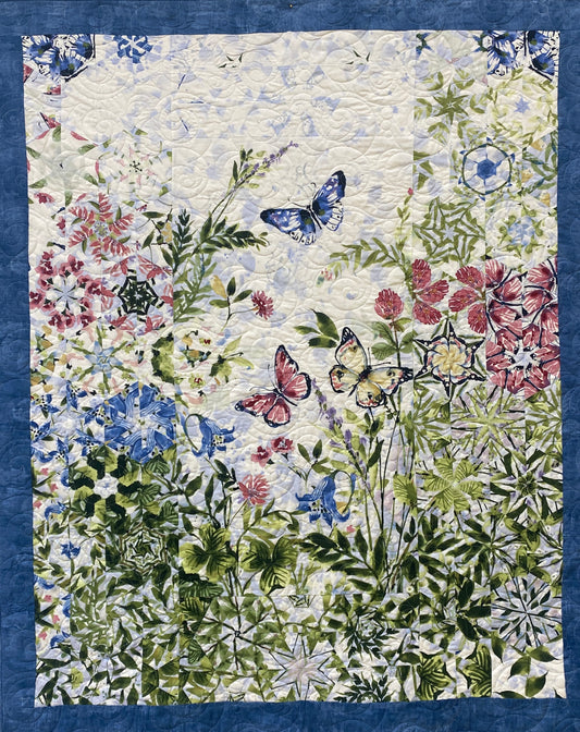 Quilt with floral and butterfly pattern on a blue background